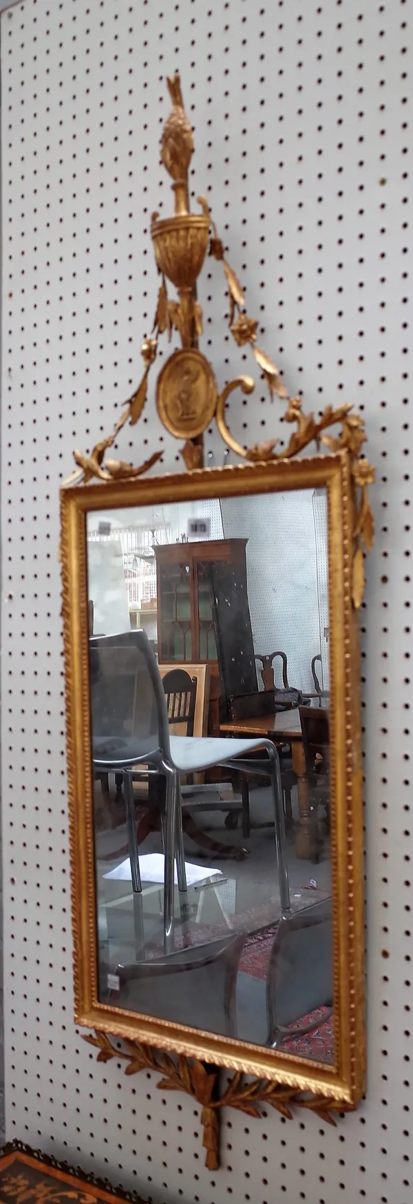 A George III gilt framed pier mirror, with urn crest over moulded frame and leaf moulded lower frieze, 46cm wide x 125cm high.