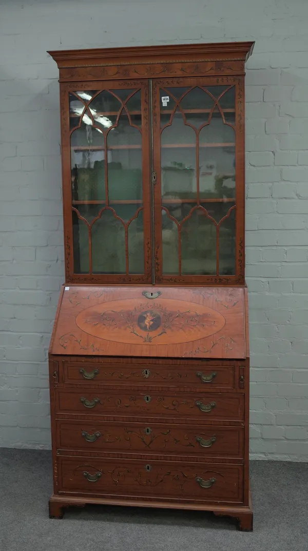 An Edwardian polychrome painted satinwood bureau bookcase, the pair of glazed doors over fitted interior and four long graduated drawers on bracket fe