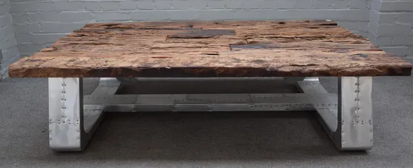 A 20th century coffee table, the planked reclaimed wood top on industrial riveted metal supports, 87cm wide x 152cm long.