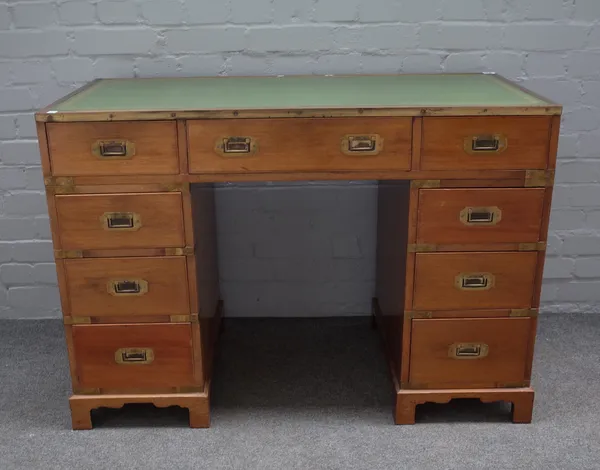 A campaign style brass bound mahogany pedestal desk with nine drawer about the knee on bracket feet, 109cm wide x 76cm high.