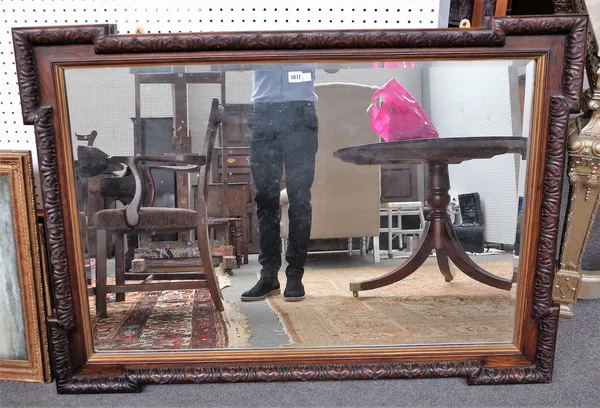 A 19th century oak rectangular mirror with outstepped square corners and leaf moulded frame, 127cm wide x 91cm high.