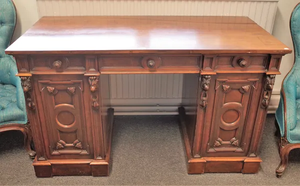 A Victorian mahogany pedestal desk with three frieze drawers over a pair of carved cupboards, 123cm wide x 62cm deep.