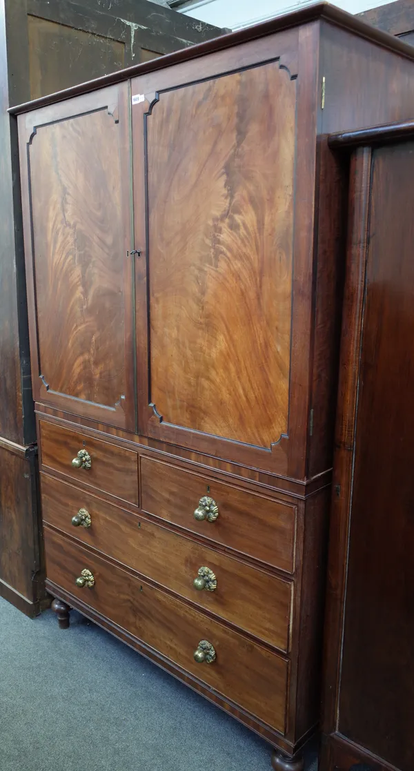 A George III mahogany linen press, the pair of panel doors over two short and two long drawers on turned feet, 128cm wide x 206cm high.