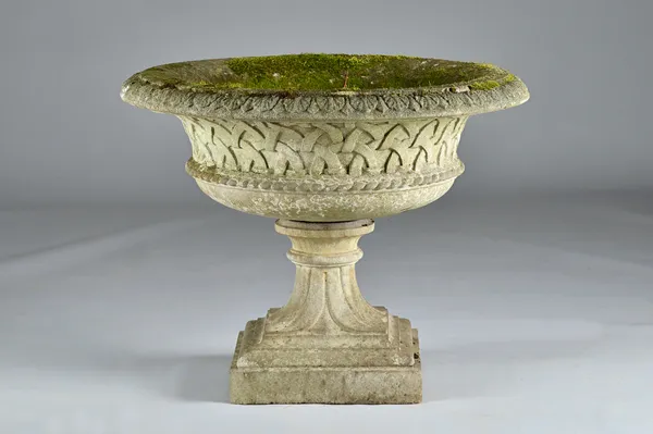 A reconstituted stone jardiniere with lattice body and fluted socle, 77cm diameter x 65cm high.  Illustrated.