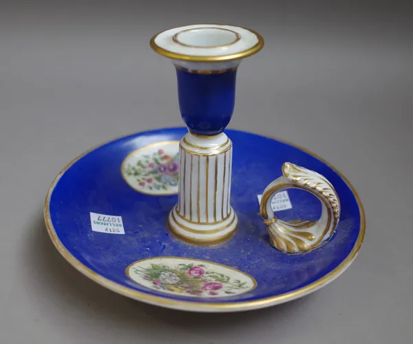 A Berlin porcelain chamber candlestick, second half 19th century, painted with two oval flower panels against a blue ground, blue printed marks, 12.5c