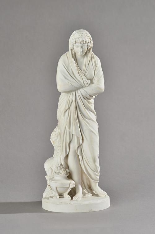 A Sevres white biscuit porcelain figure, circa 1910, probably emblematic of Winter, modelled as a young woman standing before a tree stump with a braz