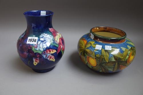 A Moorcroft pottery vase circa. 1930, tube line decoration with pansies against a mottled blue ground (20cm high) and a Doulton Lambeth faience bowl c