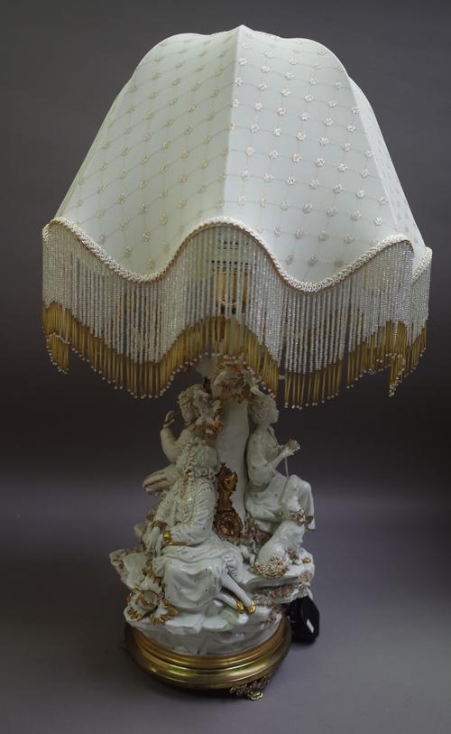 A Capodimonte porcelain figural table lamp on a gilt metal circular base and with shaped beadwork shade, blue imprinted mark, 72cm high overall.