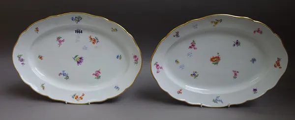 A pair of large Meissen shaped oval dishes, circa 1900, each painted with scattered flowers inside gilt-line rims, blue crossed swords mark, 42cm. wid