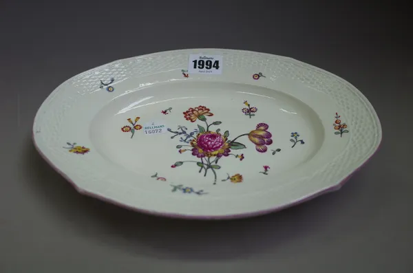 A Frankenthal small oval dish, 1770's, painted with a flower spray and sprigs beneath a basket moulded border, blue painted mark. 25cm. wide.