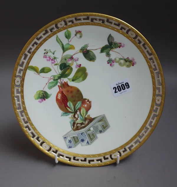 A Mintons bone china Aesthetic movement plate, circa 1880, painted with pomegranates and flowers on a stand inside a pierced key pattern border, puce