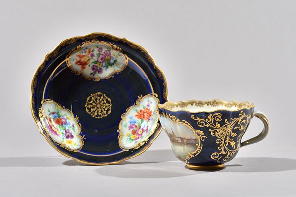 A large Meissen blue-ground cup and saucer, late 19th century, the cup painted with a titled view, `Dresden', within a gilt frame, the saucer reserved