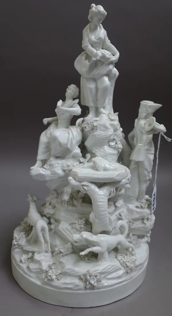 A Paris white glazed porcelain hunting group, 19th century, modelled as huntsmen and young woman on a rocky mound, a dog chasing a stag around the cir