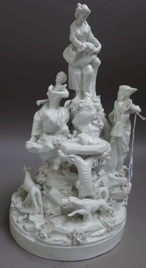 A Paris white glazed porcelain hunting group, 19th century, modelled as huntsmen and young woman on a rocky mound, a dog chasing a stag around the cir