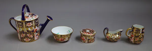 A group of Royal Crown Derby `Imari' miniatures, early 20th century, comprising; a watering can, a mug, a jug, a bowl, a cylindrical jar and cover, pr