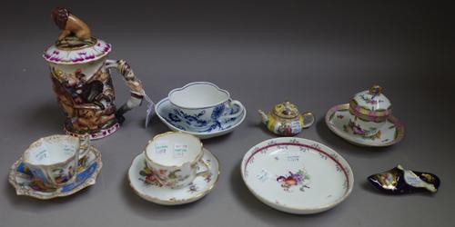 A group of Continental porcelain, mostly late 19th century, comprising; a `Naples' cylindrical mug and cover moulded with a battle scene,18cm, high; a