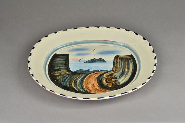 James Campbell, a hump moulded dish decorated with a chough flying over cliffs, signed and dated 97.  DDS Illustrated.