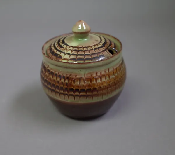 Sidney Tustin (1914-2005) a lidded jar, glazed slip decorated, maker and Winchcombe Pottery marks, 9cm high, (a.f.).  DDS