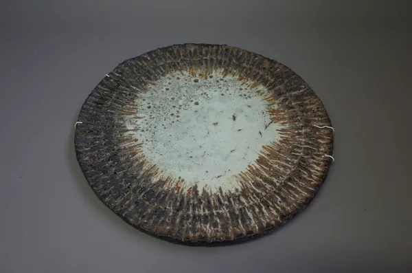 A large plaque, stoneware with worked surface and multi glazes, signed, 43cm diameter.