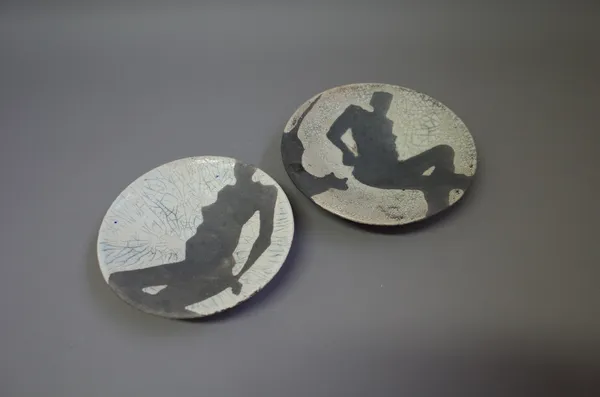 Josse Davis (born 1959), two raku dishes decorated with nudes with tin glaze and heavy carbonising, both signed and dated 1991, 19cm diameter, (2).