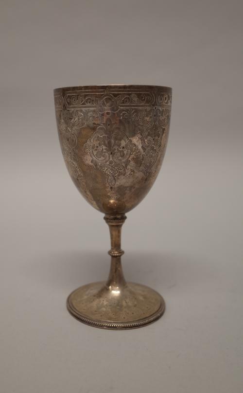 A Victorian silver cup, with feathered scroll engraved decoration, raised on a trumpet shaped circular foot, decorated with reeded bands, presentation