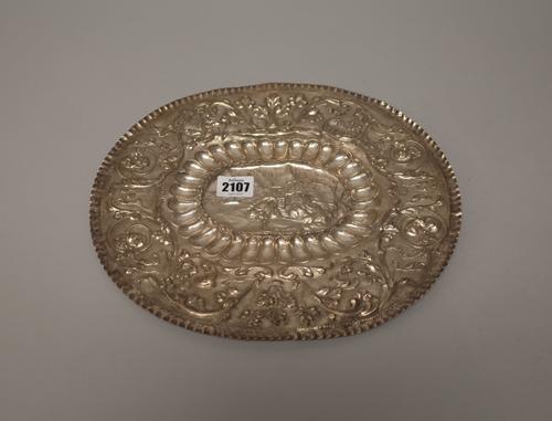 An Eastern European oval salver of panel shaped form, embossed with a castle and a ship to the centre in a lobed border and with a wide rim, embossed
