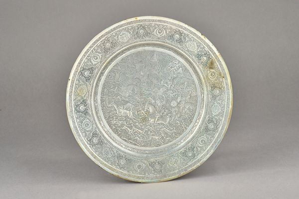 A Persian dish, decorated to the centre with figures on horseback in a hunting scene, within a wide border with foliate engraved decoration, diameter