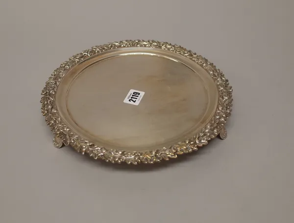 A William IV silver salver, of circular form, decorated with a cast border of oak leaves and acorns, raised on three feet, London 1836,diameter 27cm,