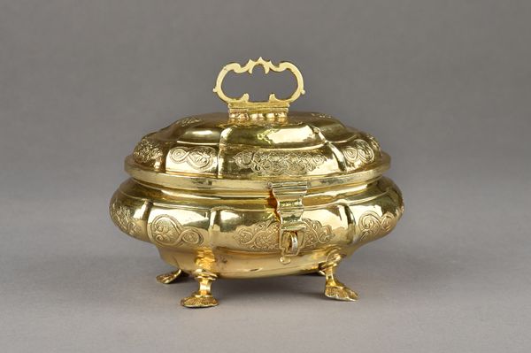 A European silver gilt sugar box, of cartouche shaped form, with scroll engraved decoration, the hinged lid with a hinged handle and with a folding ca