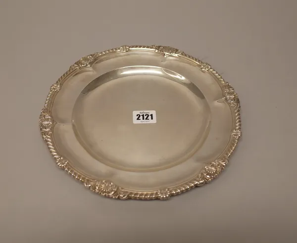 A late Victorian silver plate, of shaped circular form, decorated with a gadrooned rim, with scallop motifs at intervals, diameter 26.5cm, London 1893