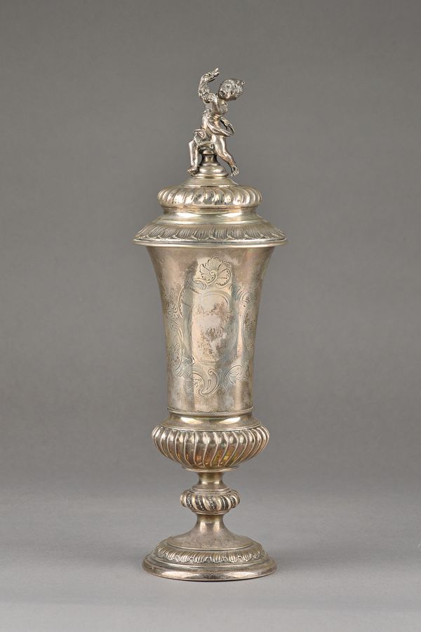 A German cup and cover, the swept body with floral and scroll engraved decoration above a spiral fluted knopped stem, raised on a circular decorated f