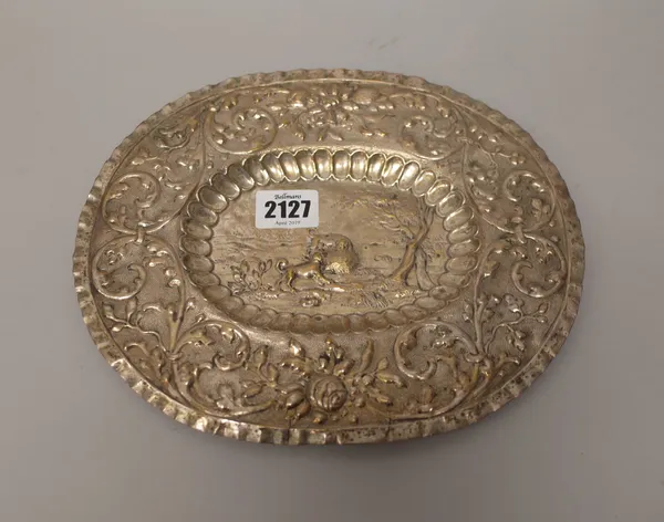 An Eastern European oval salver of panel shaped form, embossed with a dog hunting scene, with a tree in the foreground in a landscape setting to the c