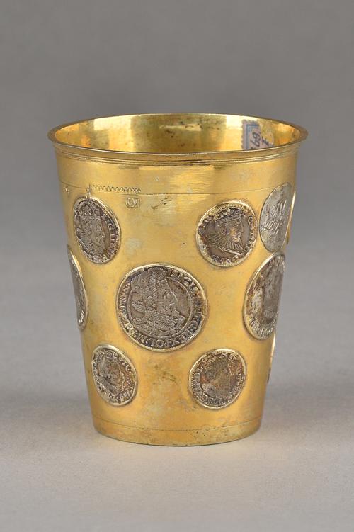 A European gilt beaker, of tapering cylindrical form, mounted with various mostly Polish coins, 16th and 17th century dates, height 9.7cm, gross weigh