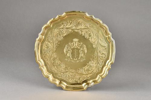 A German silver gilt salver, of shaped circular form, with a pie-crust rim, engraved to the centre with a coat of arms and a motto, within a floral an