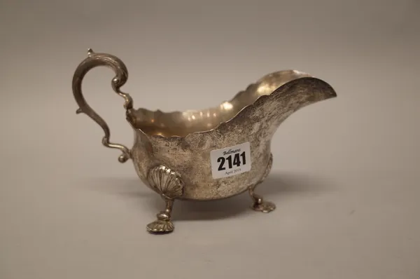 A silver large sauceboat, having a scrolling handle, raised on three pad feet, presentation inscribed, London 1937, weight 363 gms.