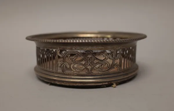 A George III silver bottle coaster, with scroll and arcaded pierced and engraved decoration within a gadrooned rim, with a turned wooden centre, diame