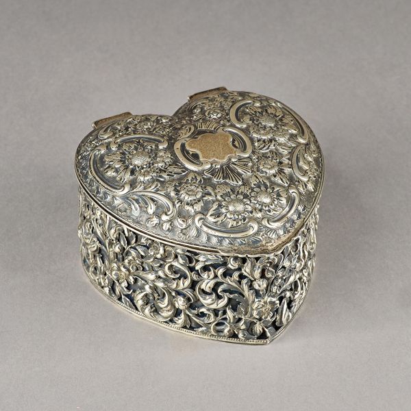 A Victorian silver heart shaped hinge lidded trinket box, with floral, foliate and scroll embossed and pierced decoration, blue textile and velvet lin