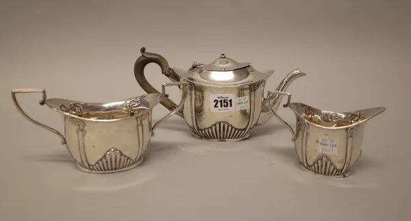 A silver three piece tea set, comprising; a teapot, a twin handled sugar bowl and a milk jug, each piece of oval form, with partly fluted decoration,