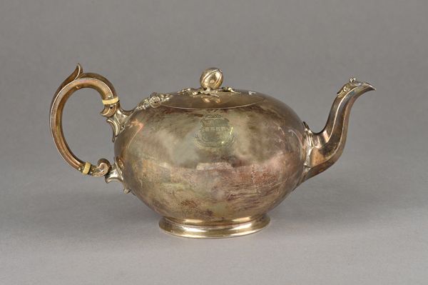 A Victorian silver teapot of compressed circular form, the hinged lid with a bud finial, the body shield and motto engraved, raised on a circular foot