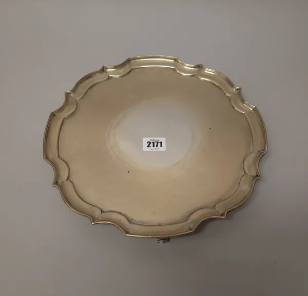 A silver salver, of shaped circular form, having a pie-crust rim, raised on four scrolling feet, in the Chippendale taste, Sheffield 1918, weight 798