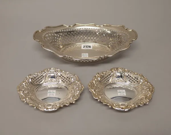 Silver, comprising; a shaped oval boat shaped basket, with pierced decoration within a scrolled rim, Sheffield 1906, length 27.5cm and a pair of shape