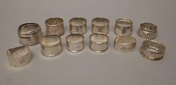 A pair of silver napkin rings, with engraved decoration within cast rims, London 1919, seven further silver napkin rings, in a variety of designs, com