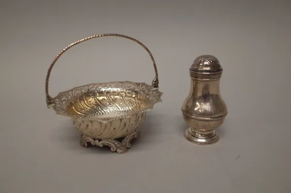 A George III silver basket, of shaped circular form, with embossed and pierced decoration and with a swingover handle, London 1760 and a silver pepper