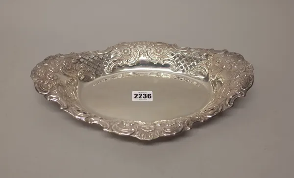 A late Victorian silver dish, of shaped oval form, the wide border with floral, foliate and scroll embossed and pierced decoration, length 32cm, Sheff