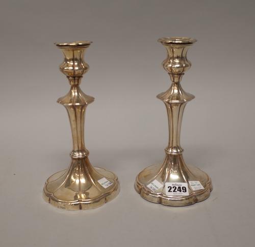 A pair of silver table candlesticks, each with a tapered stem, on a swept lobed base, Sheffield 1906, (loaded), height 21.5cm.