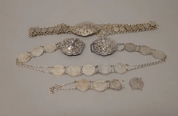 A waist belt spaced with Burmese coins at intervals, the two piece clasp decorated with Burmese deity style figures and an Asian waist belt, the links