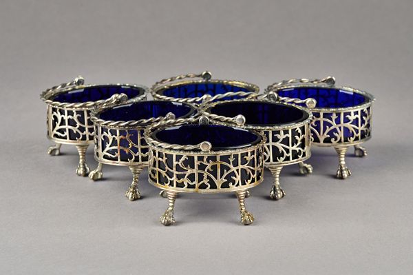 A Victorian set of six silver salts, each of oval form, with scroll pierced decoration below a gadrooned rim, raised on four paw feet, with a swingove