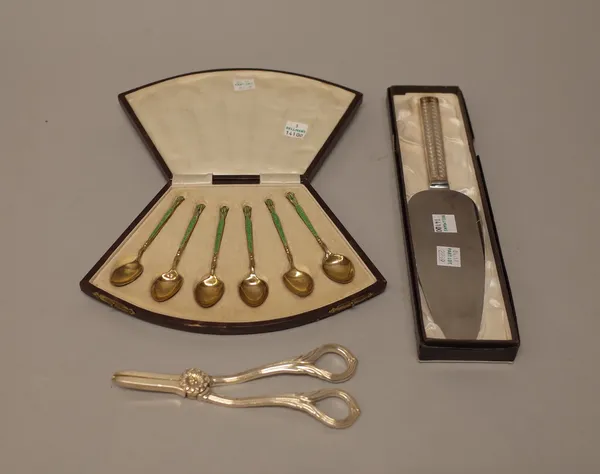 A set of six silver gilt and enamelled coffee spoons, the backs of the bowls with floral decoration, Birmingham 1929, with a fitted fan shaped case, a