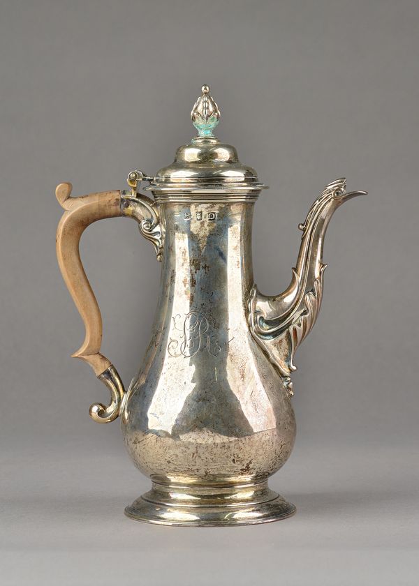 A late George II silver coffee pot, of baluster form, the hinged lid with a stylized bud finial, the body monogram engraved, raised on a circular foot