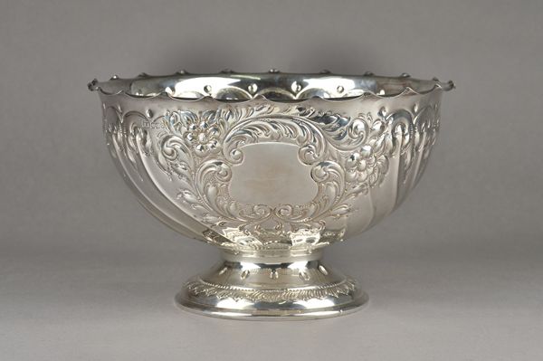 A silver rose bowl, embossed with foliate capped spiral fluted decoration and with a vacant cartouche decorated with a floral surround, raised on a ci